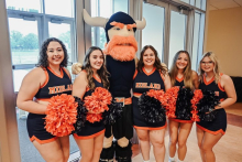 Magnus the mascot and cheerleaders at Homecoming.